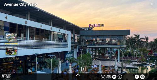 a large building with a restaurant and palm trees at Maison 7 in El Obour