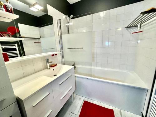 y baño con lavabo blanco, bañera y ducha. en Gîte Pomme Verte - BY PRIMO C0NCIERGERIE, en Vonnas