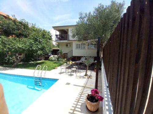 une maison avec une piscine à côté d'une clôture dans l'établissement Apartment Kućica, à Zadar