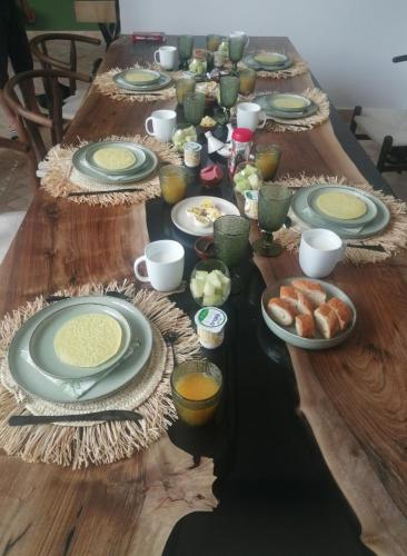 a long wooden table with plates of food on it at Riad Belharra in Marrakech