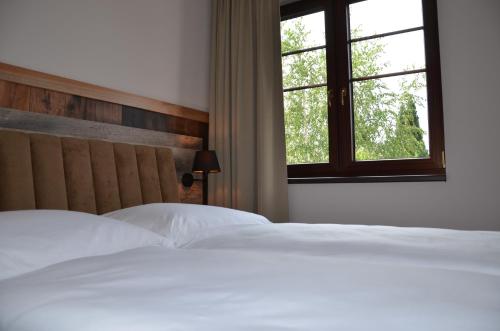 two white beds in a bedroom with a window at FloraVilla in Rajecké Teplice