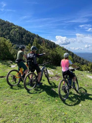 three people riding bikes on a grassy hill at Hotel Can Pamplona in Vic