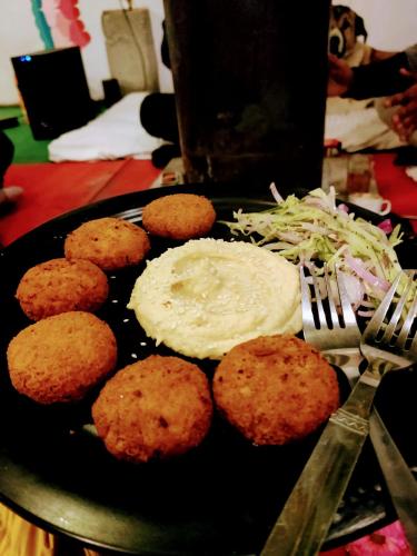 a plate of food with eggs and coleslaw on a table at Safar Hostel Manali in Manāli