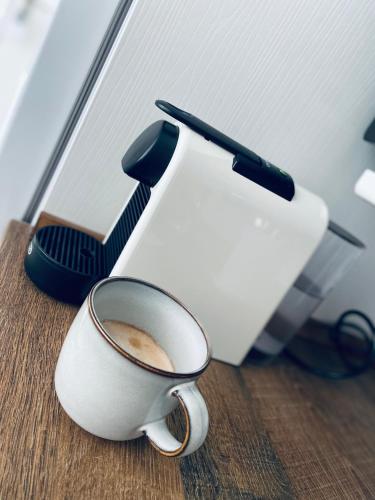 a cup of coffee sitting on a table next to a toaster at Casa Pandora Apartamento Duplex Atico, primera línea de playa Torrox in Torrox Costa