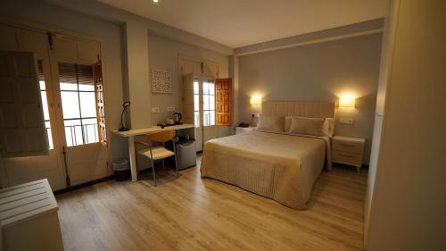 a bedroom with a bed and a desk in it at Hotel Infante Antequera in Antequera