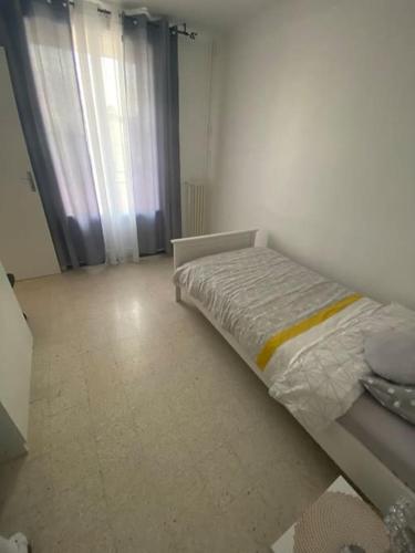 une petite chambre avec un lit et une fenêtre dans l'établissement Appartement T4 à deux pas de la gare St Charles, à Marseille