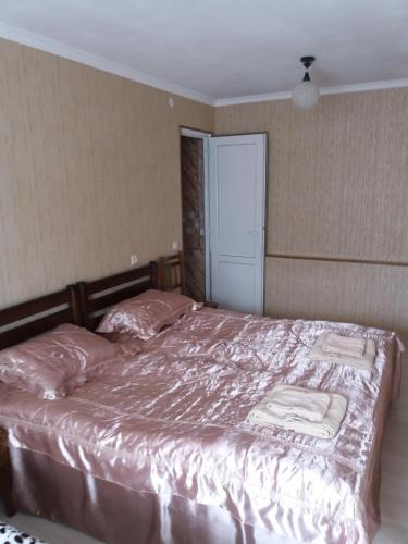 um quarto com uma cama grande e lençóis cor-de-rosa em MerabKostava st.N9 em Akhalubani