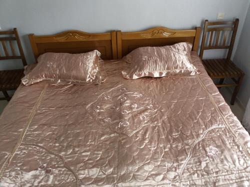Una cama sin hacer con dos almohadas encima. en MerabKostava st.N9, en Akhalubani