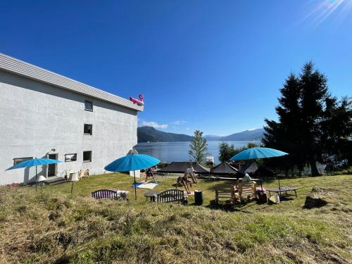 a group of people sitting under umbrellas near a building at Balestrand Hotel in Balestrand