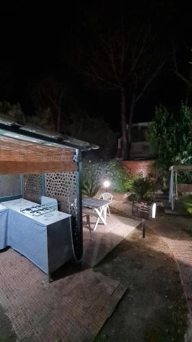 a patio with a table and a bench at night at Villa Matisse - Damecuta Park in Anacapri
