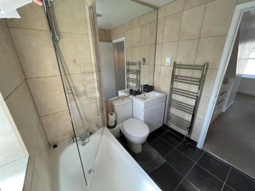 a bathroom with a tub and a toilet and a shower at Bright one bed apartment with free parking in Brighton & Hove