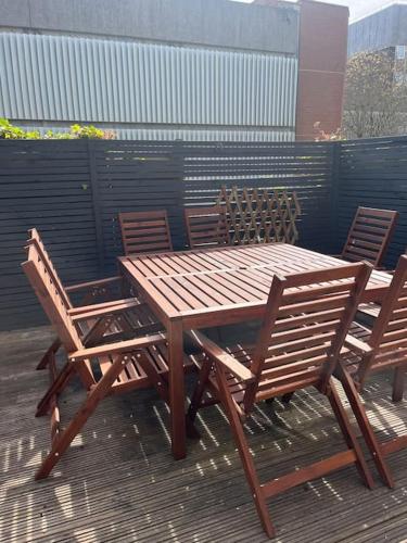 a wooden table and chairs sitting next to a fence at Bright one bed apartment with free parking in Brighton & Hove