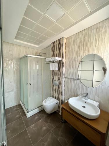 a bathroom with a sink and a toilet and a mirror at F&G BUTİK HOTEL in Alacati