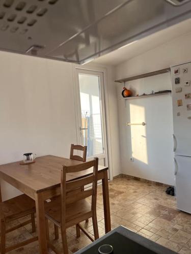 ベオグラードにあるApartment Gloria 4 NEWの木製のテーブルと冷蔵庫のあるキッチン