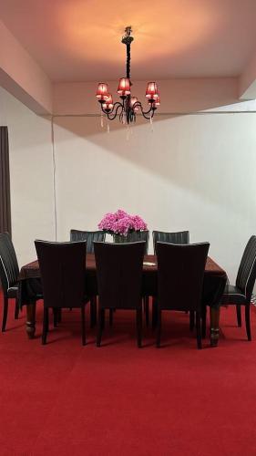 een eetkamer met een tafel met stoelen en een kroonluchter bij Kama BDS Homestay Temerloh in Temerloh