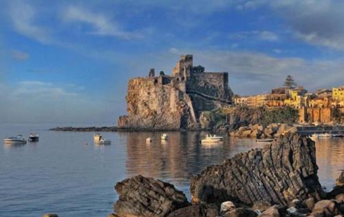 ein Schloss auf einer felsigen Insel im Wasser in der Unterkunft Casa Martina in Aci Castello
