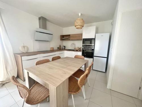 une cuisine avec une table et des chaises en bois dans l'établissement Alma Terra - Terrasse privative, à Lagord