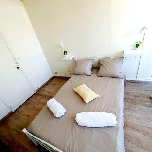 a bed with two pillows on it in a room at Votre chambre chez l'habitant dans la capitale de la Normandie in Rouen