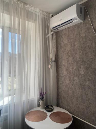 Habitación con mesa blanca y ventana en Комфортабельные - Уютные апартаменты в Костанай Алтын Арман en Kostanái
