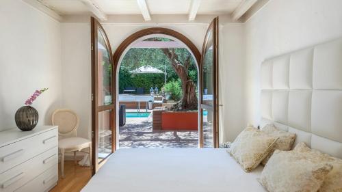 a bedroom with a bed and an archway at VILLA ROSSA 12, Emma Villas in Misano Adriatico