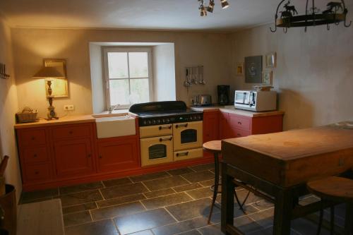a kitchen with an oven and a table in it at La ferme Claudlisse in Vielsalm