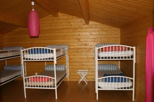 a room with three bunk beds in a cabin at Auberge De La Foret Bonifatu in Calenzana