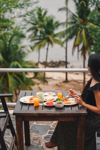 een vrouw die aan een tafel zit met een bord eten bij Kooncharaburi Resort - Koh Chang in Ko Chang