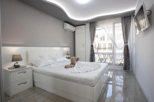 Un dormitorio blanco con una cama grande y una ventana en Апартамент за гости Ивви-1, en Burgas
