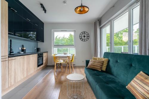 a living room with a green couch and a table at Symphony Baltica Towers Apartamenty in Gdańsk