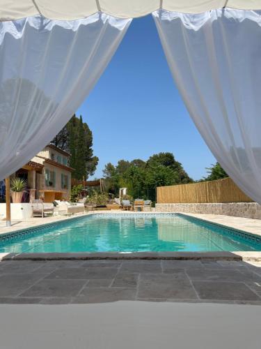 a swimming pool with a white curtain over it at Les jardins de Manotte in La Motte