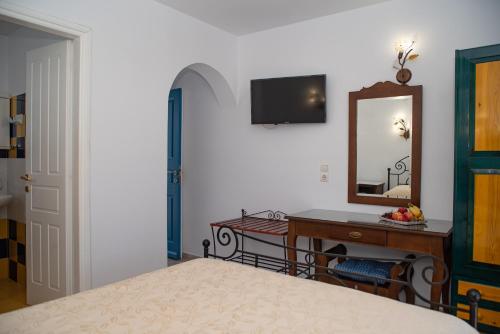 a bedroom with a bed and a mirror and a desk at Deep Blue in Agios Prokopios
