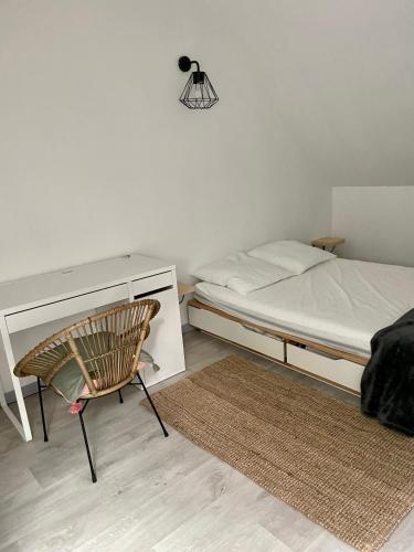 une chambre avec un lit, un bureau et une chaise dans l'établissement Appartement cosy à la campagne, à Languidic