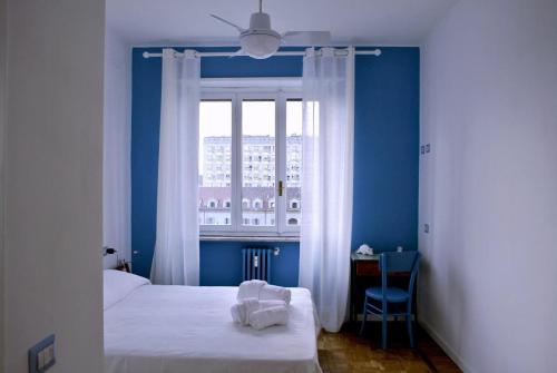 Dormitorio azul con cama y ventana en Il Cielo Sopra Torino, en Turín