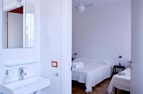 Baño blanco con lavabo y espejo en Il Cielo Sopra Torino, en Turín