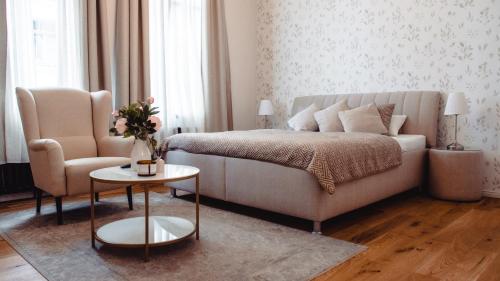 - une chambre avec un lit, un canapé et une chaise dans l'établissement Grâce Boutique Apartments, à Halle-sur-Saale