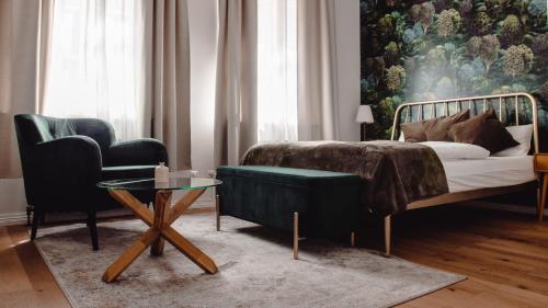 a bedroom with a bed and a couch and a table at Grâce Boutique Apartments in Halle an der Saale