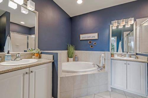 a bathroom with two sinks and a tub at Golf Condo- Resort Pool- LakeView- 10mi to beaches in Naples