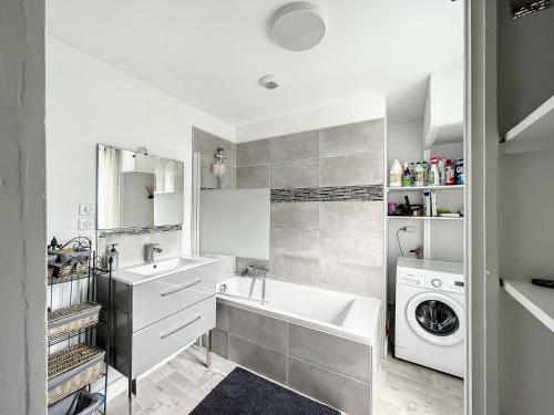 une salle de bain avec un lavabo et une machine à laver dans l'établissement Le Vintage - 15 min FUTUROSCOPE, à Poitiers