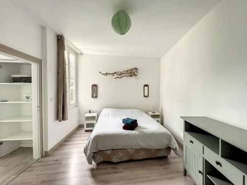 a white bedroom with a bed and a dresser at Le Vintage - 15 min FUTUROSCOPE in Poitiers