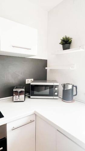 a white kitchen with a microwave on a counter at 2 ZKB Apartment in Mannheim in Mannheim