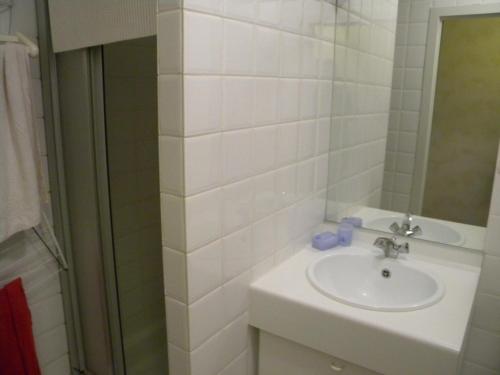 een witte badkamer met een wastafel en een douche bij Zandvlugge 0303 in Koksijde