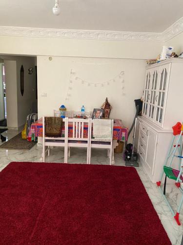 un soggiorno con tavolo e tappeto rosso di Campchizar sea view Apartment ad Alessandria d'Egitto