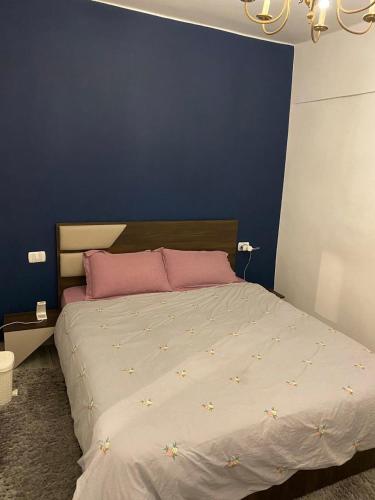 una camera con un grande letto con una parete blu di Campchizar sea view Apartment ad Alessandria d'Egitto