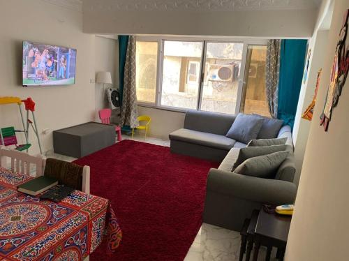 un soggiorno con divano e tappeto rosso di Campchizar sea view Apartment ad Alessandria d'Egitto
