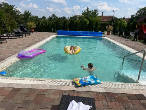 two children are playing in a swimming pool at Meggyes Hotel in Szerencs