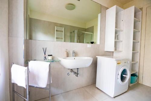 a bathroom with a sink and a washing machine at Prime blue suite - Giardini in Riccione