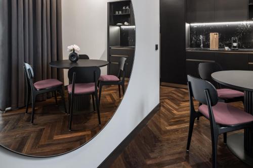 a dining room with tables and chairs and a wall at AMANO Home Leipzig in Leipzig