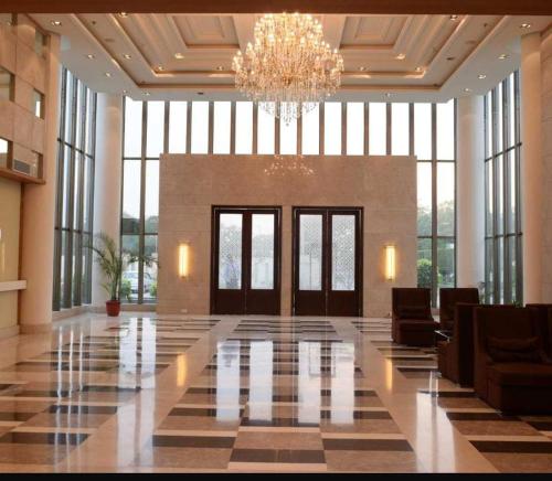 a lobby with a chandelier and a large room at CALISTA RESORT in New Delhi