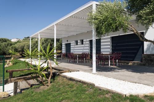une maison avec une terrasse dotée de tables et de chaises dans l'établissement Villa - Finca Florida Benalup, à Benalup-Casas Viejas