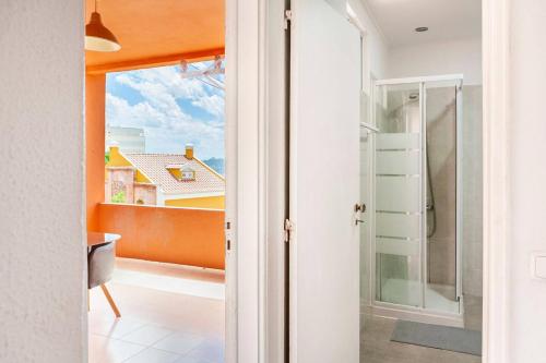 uma casa de banho com uma porta de vidro que leva a uma varanda em Relax in Lisbon for 4 people with terrace and parking em Lisboa
